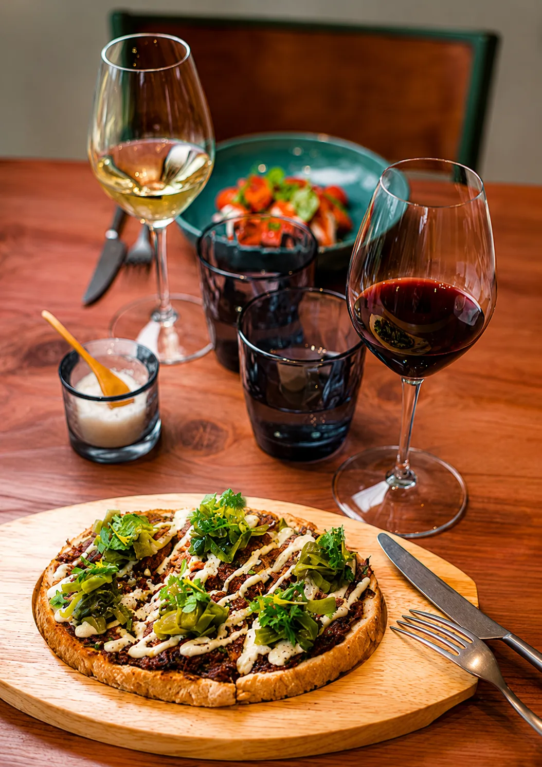 Tarte salée dressée avec deux verres de vin sur une table en bois