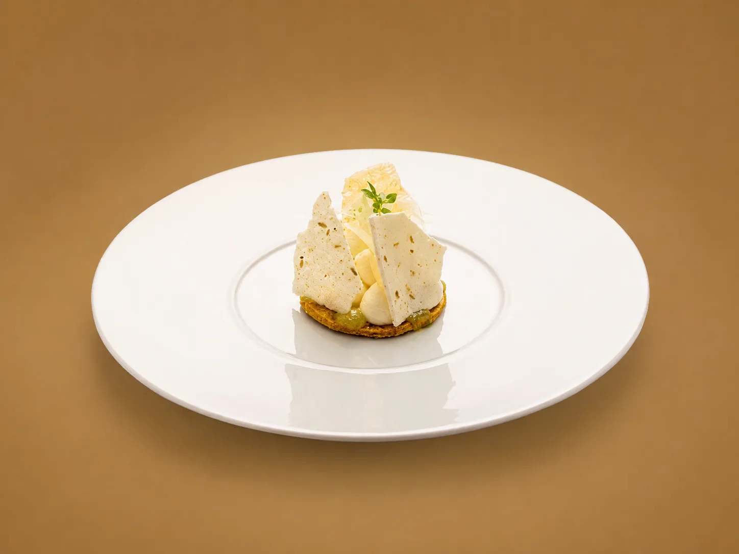 Dessert blanc aux fines tuiles dressé au centre d'une large assiette blanche